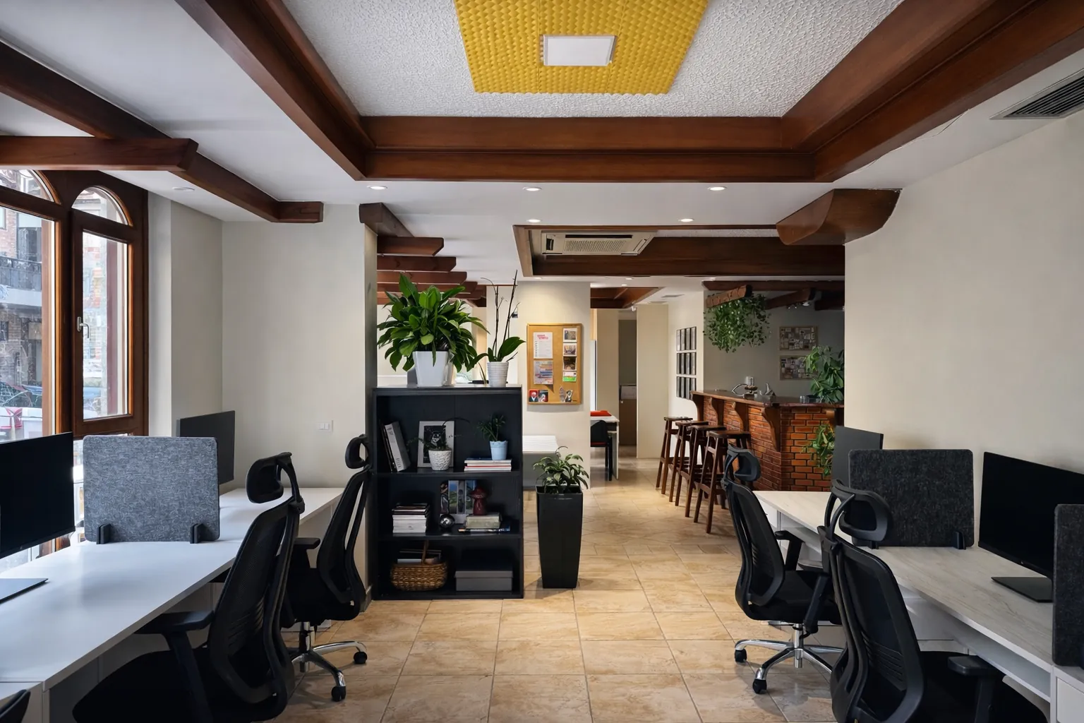 The Modul Space coworking room: white desks, wooden beams and a brick coffee bar